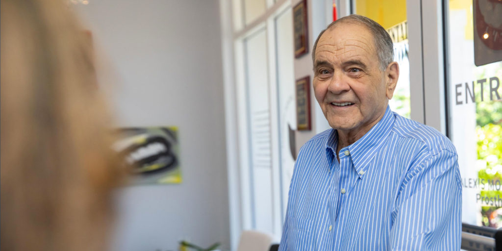 older dental patient shaking hands with office