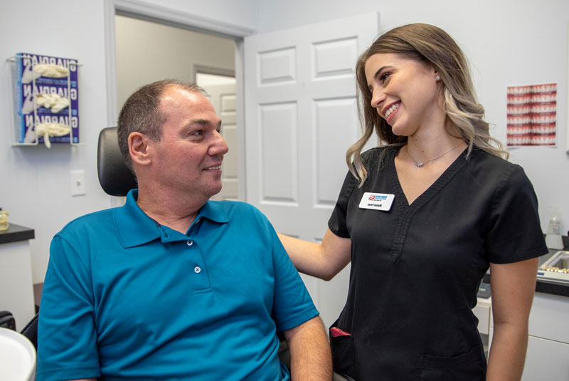 rda with dental implant patient smiling after implants